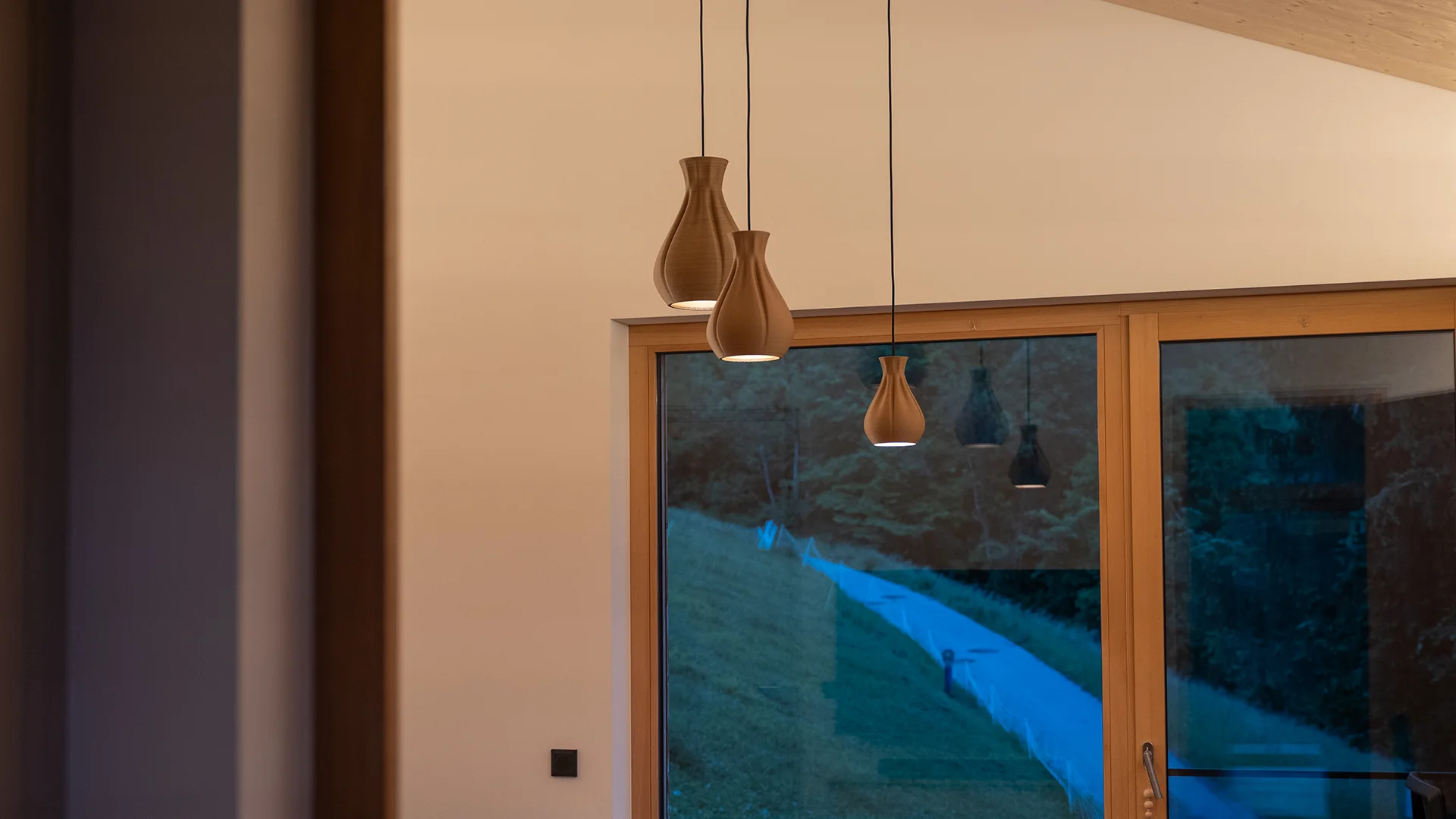 Drei Pendelleuchten vor der Fensterfront – Holzhaus im Rheintal, Conceptlicht