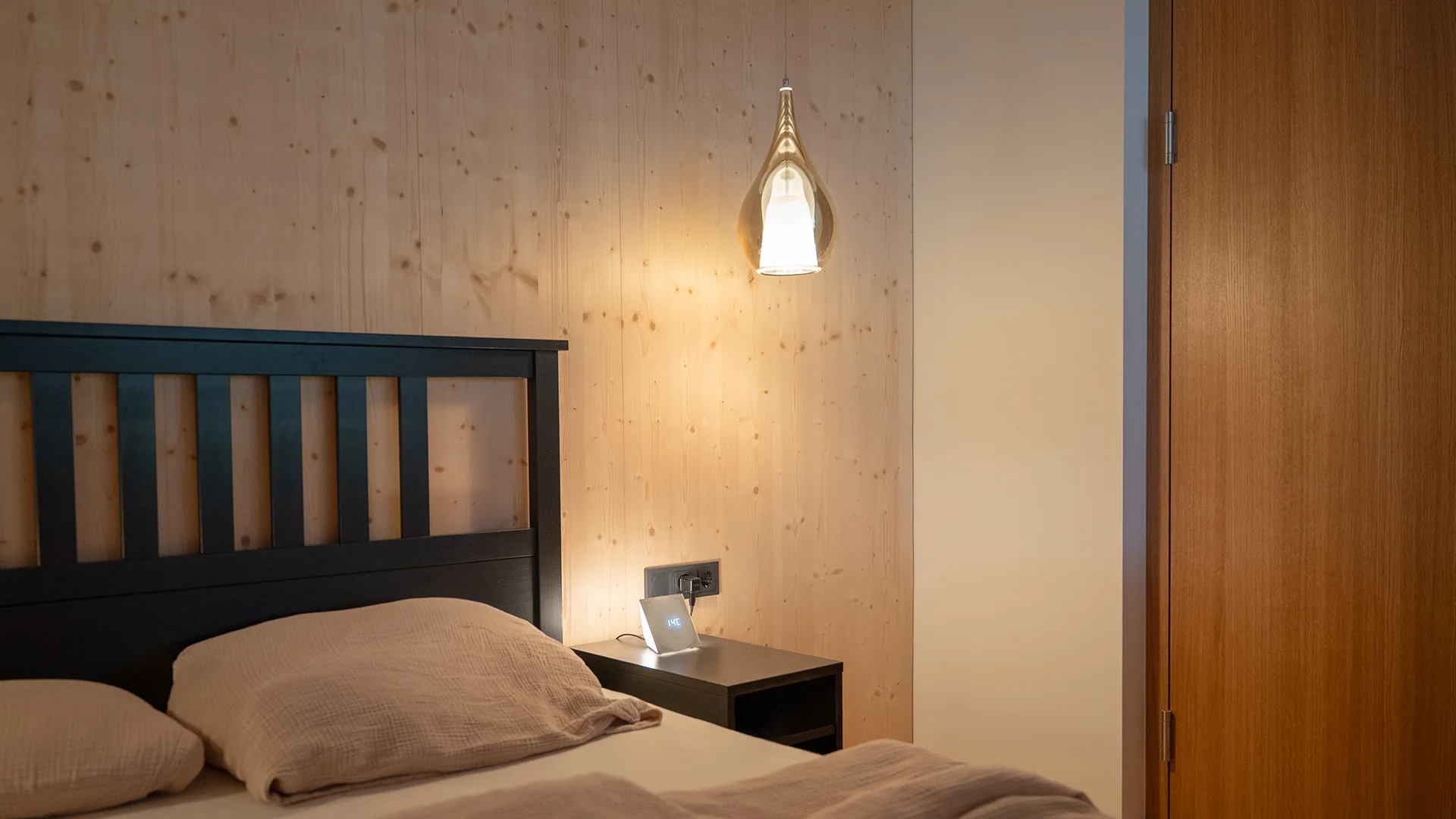 Pendelleuchte als Nachttischlicht neben dem Bett – Holzhaus im Rheintal, Conceptlicht
