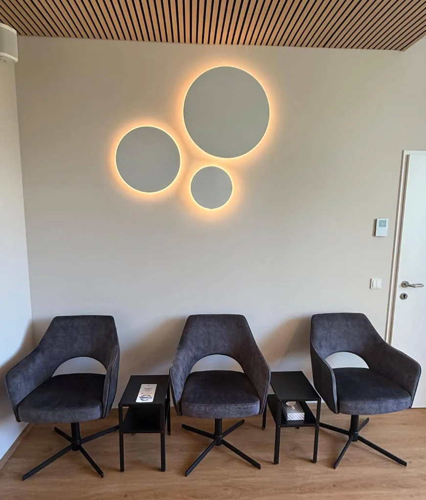 Wartebereich mit drei runden Wandleuchten und indirektem Licht – Gemeinschaftspraxis Therapiefabrik Dornbirn, Conceptlicht